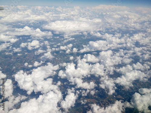 Scenic view from the airplane window. Natural beauty of blue sky with clouds. Wing of the plane. Airplane flying in the sky.