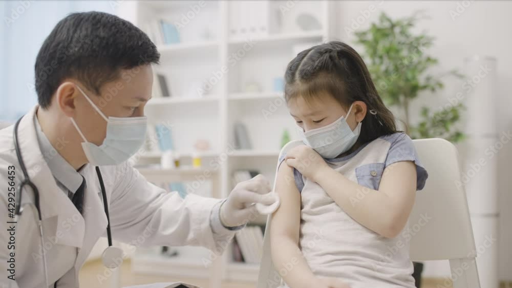 Doctor making injection to scared little girl vaccination for disease prevention Doctor making injection to scared little girl vaccination for disease prevention