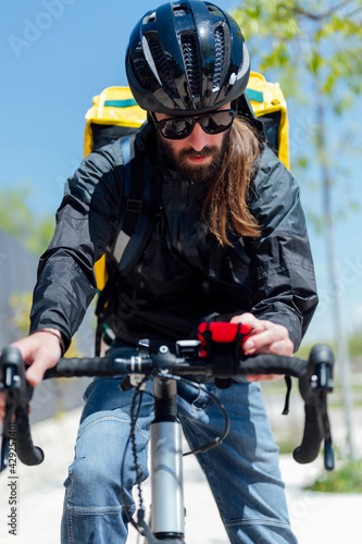 Male cyclist with messenger bag and mobile phone on street