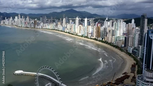 aerial image with drone hyperlapse of the city of Balneário Camboriú with the ferris wheel with beach and beachfront