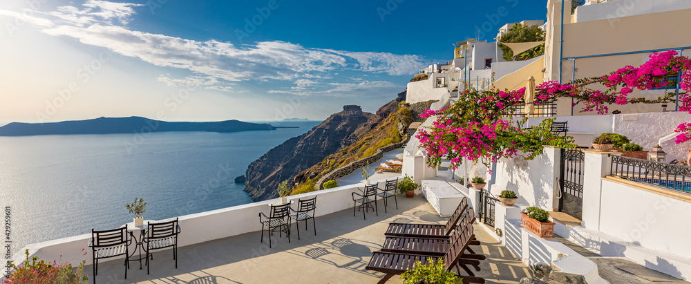 Naklejka premium Summer vacation panorama, luxury famous Europe destination. White architecture in Santorini island, Greece. Travel landscape cityscape with pink flowers, stairs, caldera view in sunlight and blue sky