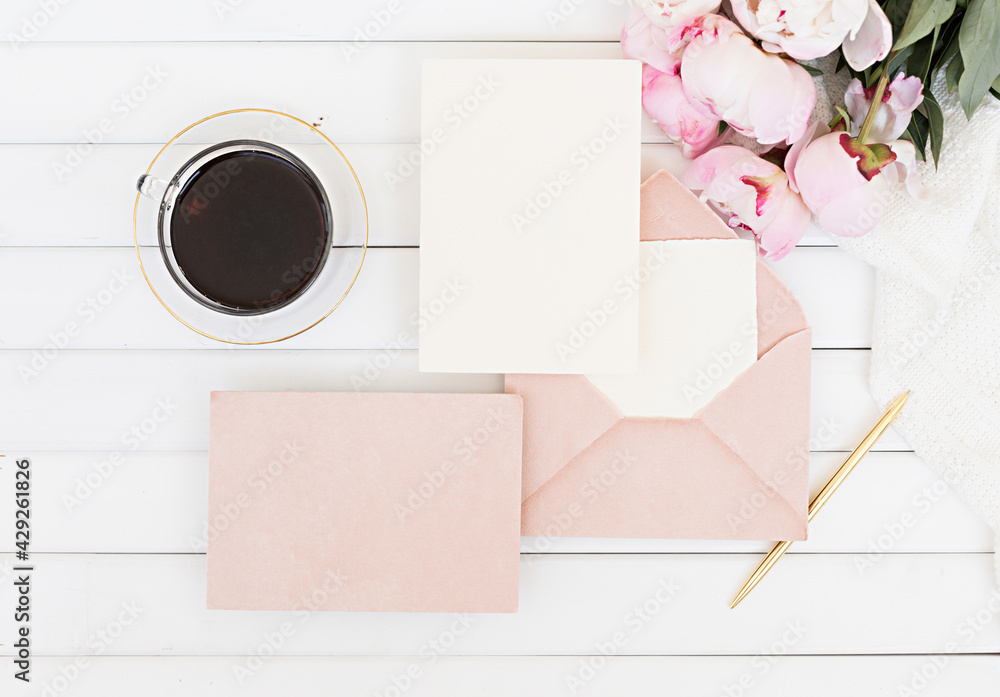 Wedding greeting card concept. Top view mockup on wooden background with peonies flowers. Flat lay style in light colors. Wedding greeting card concept. Top view mockup on wooden background with peonies flowers. Flat lay style in light colors.