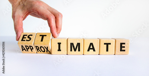 Estimate or approximate symbol. Businessman turns wooden cubes and changes the word 'approximate' to 'estimate'. Beautiful white background, copy space. Business, estimate or approximate concept. photo