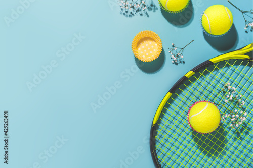 Tennis party. Holliday sport composition with yellow tennis ball and racket on a blue background of hard tennis court with copy space. Sport and healthy lifestyle. The concept of outdoor game sports