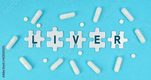 On a blue background, there are pills and puzzles with the inscription - LIVER