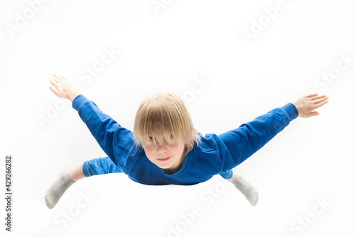 Fototapeta Naklejka Na Ścianę i Meble -  Light-haired boy in blue suit flying in the air. Isolated on white background. Dreaming concept.