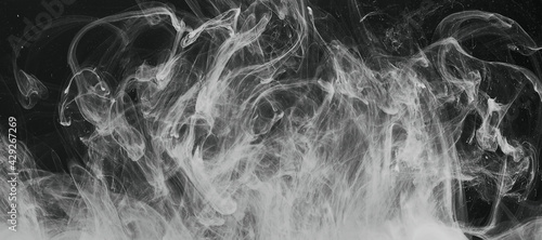 Abstract white smoke on a black background close-up.