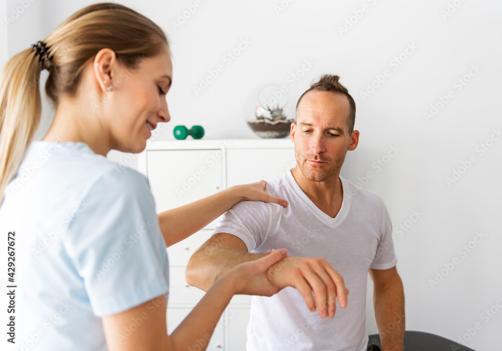 Patient at the physiotherapy doing physical exercises with his therapist Patient at the physiotherapy doing physical exercises with his therapist