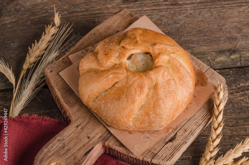 Appetizing fresh culinary pastry - beautiful curly pie with filling on wooden photo