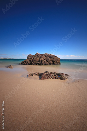 Beach with turquoise sea water with rocks. long exposure.