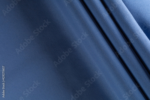 thick curtain cotton fabric of azure color, folded in folds, background
