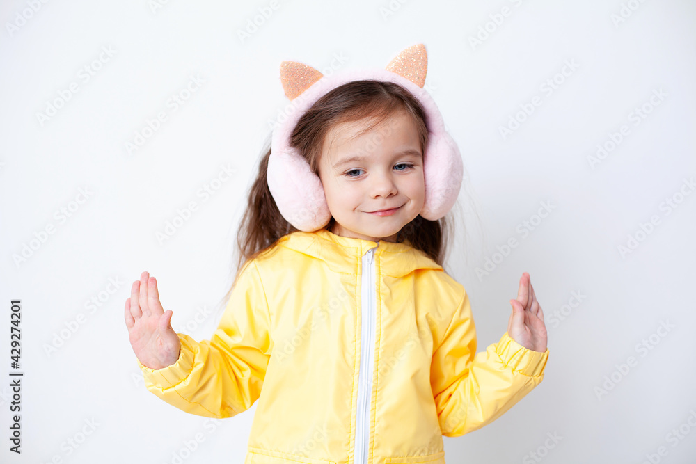 A nice girl in a yellow jacket spread her arms to the sides. Demi-season clothing. Weather in spring and autumn. Portrait on a white background. A nice girl in a yellow jacket spread her arms to the sides. Demi-season clothing. Weather in spring and autumn. Portrait on a white background.