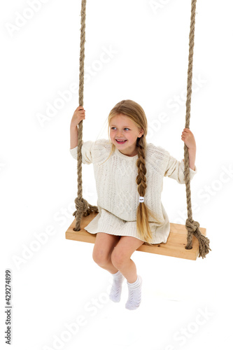 Cute long haired girl sitting on rope swing