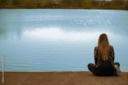 Slika na platnu person sitting on the edge of the lake