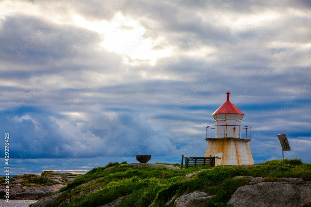 Little unmanned lighthouse in weather-hardened fishing village on the coast of Norway