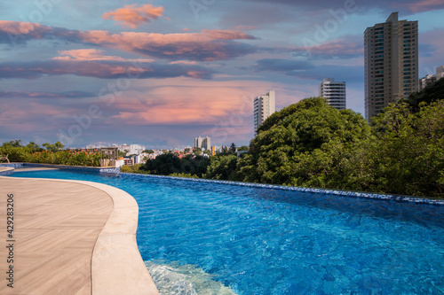 Infinity pool with trees and buildings in the background