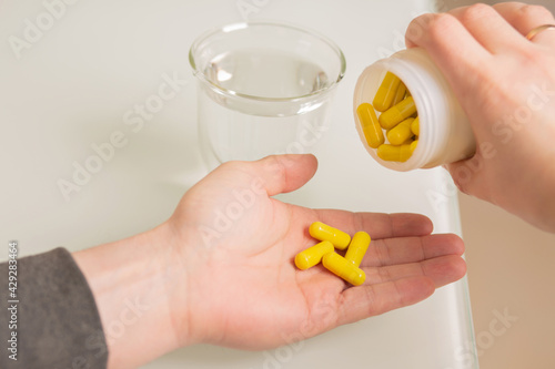 Man pours the pills capsules out of the bottle