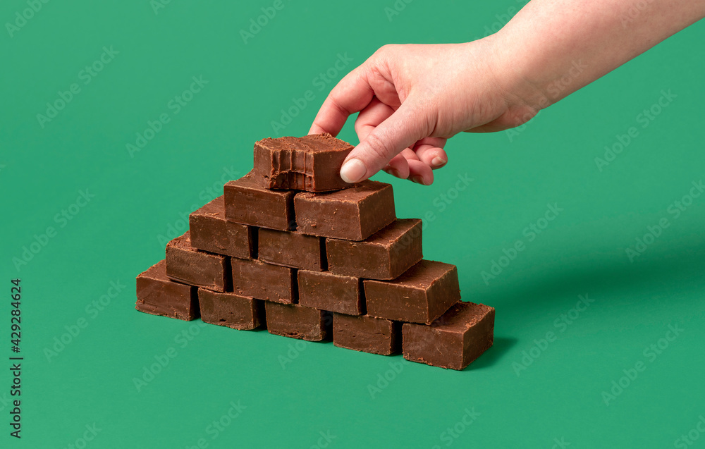 Homemade chocolate fudge. Woman hand grabbing a piece of fudge. Homemade chocolate fudge. Woman hand grabbing a piece of fudge.