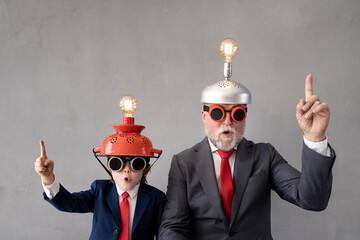 Funny child and senior man pretend to be businessmen
