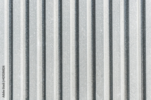 Corrugated metal sheet background. Grunge old grainy metal texture. Silver color industrial pattern. Garage construction gray striped wall. Wavy gray metal background. Metal door siding.