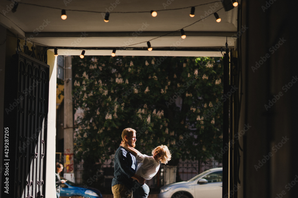 Romantic and happy caucasian couple in casual clothes walking together through the city streets. Love, relationships, romance, happiness concept. Man and woman holding hands and smiling.