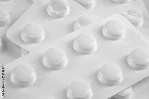 White pills in white blister on white background