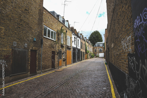 Beautiful brown brick alley with rows of small english houses in the Notting Hill, London photo