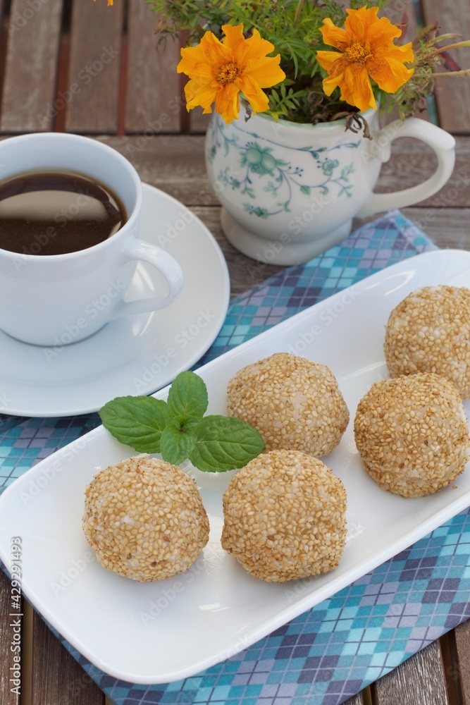 Sesame seed balls or Onde-onde. Indonesian traditional street food. glutinous rice flour stuffed with mung bean paste coated with sesame seeds. Served with a cup of coffee Sesame seed balls or Onde-onde. Indonesian traditional street food. glutinous rice flour stuffed with mung bean paste coated with sesame seeds. Served with a cup of coffee