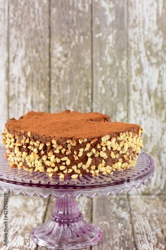Vegan raw chocolate cake with dates  almond nuts  mashed banana and cacao powder on cake stand