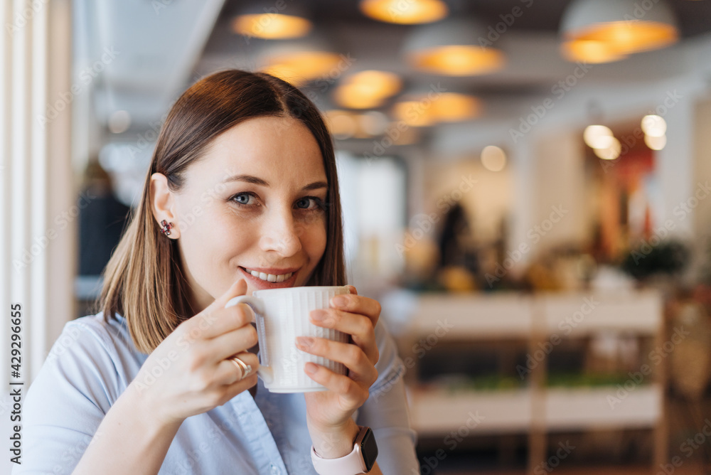 Attractive female with cute smile having a coffee while relaxin in a break Attractive female with cute smile having a coffee while relaxin in a break