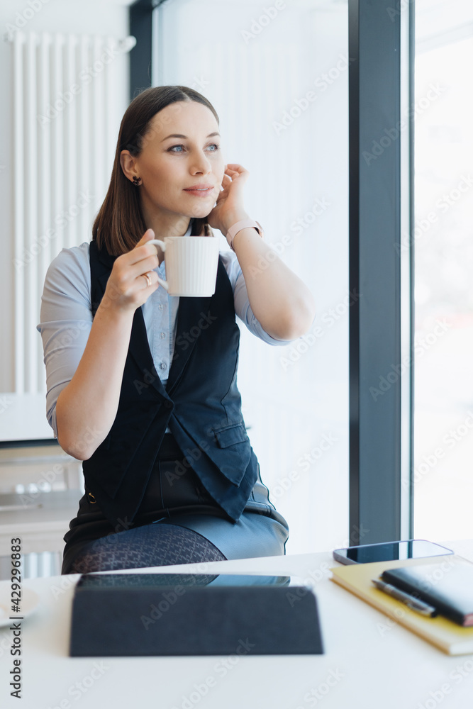 Attractive female with cute smile having a coffee while relaxin in a break Attractive female with cute smile having a coffee while relaxin in a break
