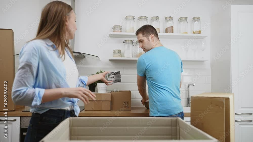 Family couple unpacking boxes after moving to new apartment. Family couple unpacking boxes after moving to new apartment.