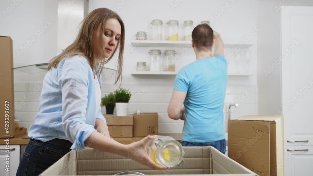 Family couple unpacking boxes after moving to new apartment. Family couple unpacking boxes after moving to new apartment.