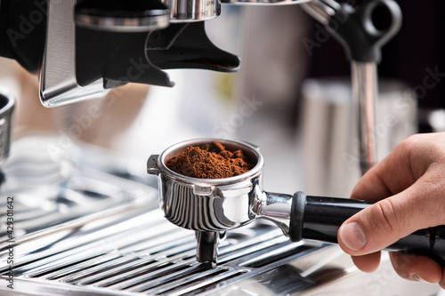 freshly ground coffee beans in a portafilter by the coffee grinder freshly ground coffee beans in a portafilter by the coffee grinder freshly ground coffee beans