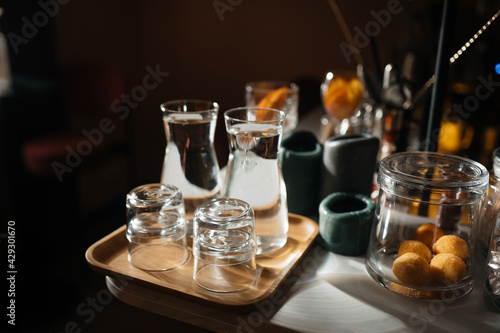 Four glass cups on the bar counter with serving accessories.