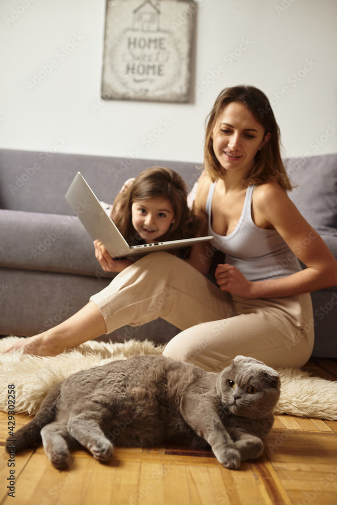 daughter watching mom work on computer daughter watching mom work on computer