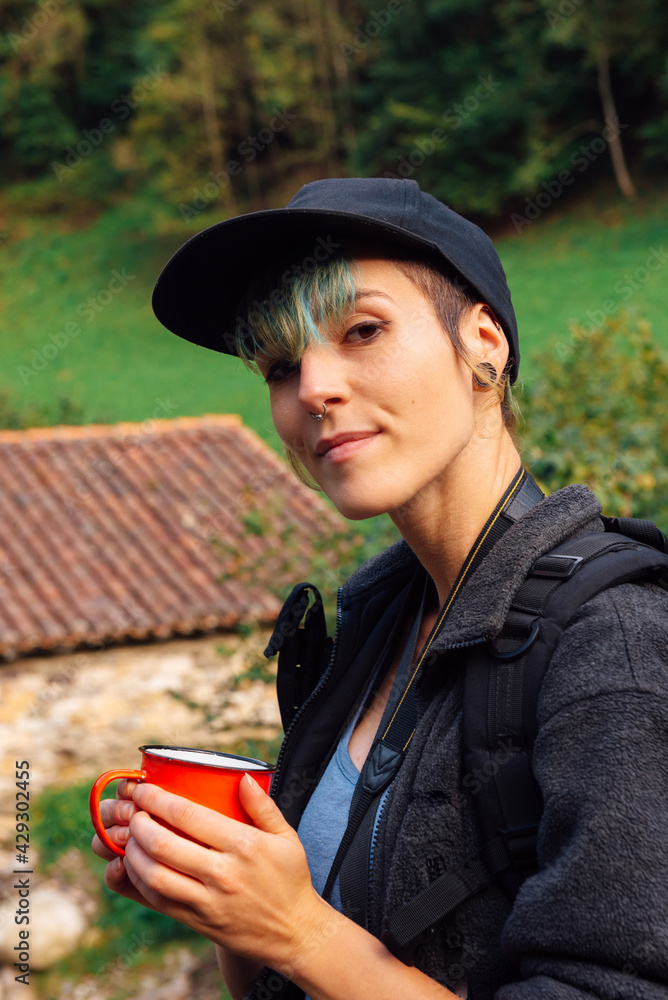 mountaineer having a coffee during a break in the forest. young woman doing hiking. outdoor sports. mountaineer having a coffee during a break in the forest. young woman doing hiking. outdoor sports.