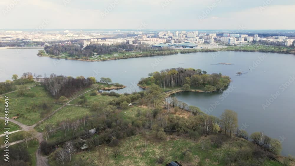 Flight in the spring city park. towards the reservoir. The city block is visible in the distance. Flight in the spring city park. towards the reservoir. The city block is visible in the distance.