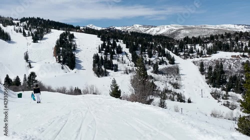 April 3, 2021 Deer Valley, Utah. Skiers going down a gentle slope overlooking the valley photo