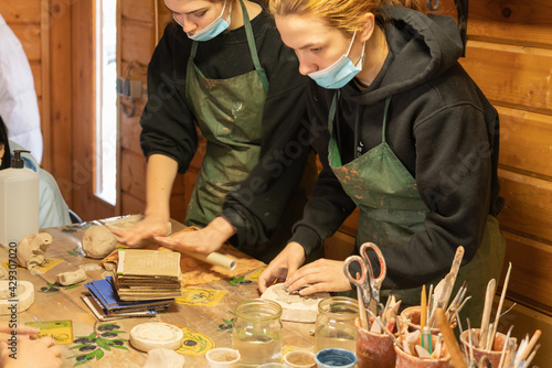 A young woman is learning pottery. Clay modeling master class. Carpathians. Ukraine. photo