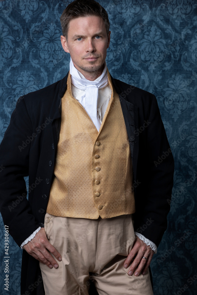 A handsome Regency gentleman wearing a gold waistcoat, breeches, and a ...