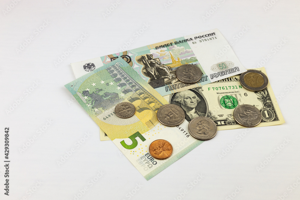 Dollars, euros, rubles, coins are in disarray on white background. Money exchange concept. Close-up, selective focus. Dollars, euros, rubles, coins are in disarray on white background. Money exchange concept. Close-up, selective focus.