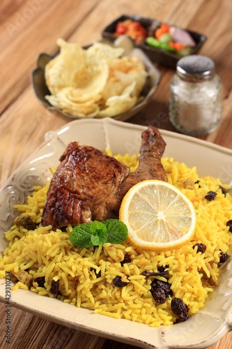Delicious Chicken Biryani On Ceramic Plate. Briyani Dish Beautiful Indian Rice Dish. Delicious Roast Spicy Chicken biryani in Square Plate Over Moody Background, Popular Indian, Arab, and Pakistani.