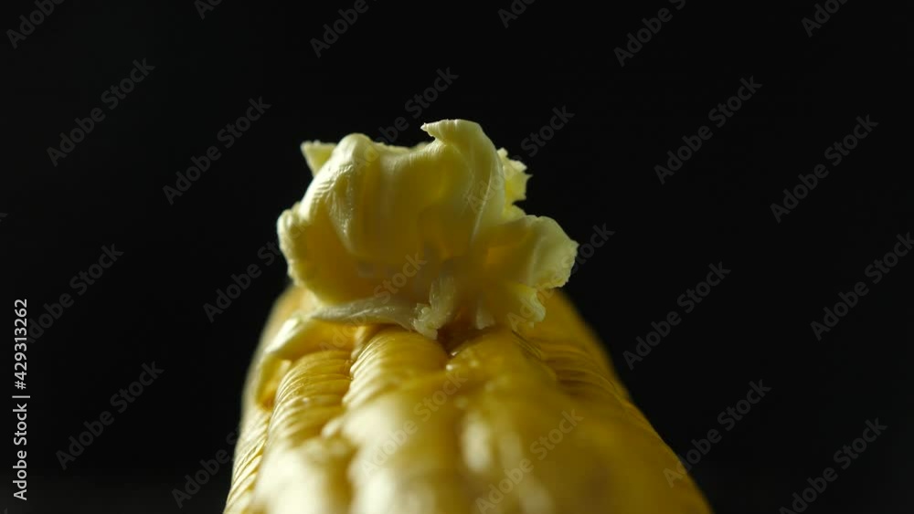 Melting butter on rotated hot freshly boiled corn close-up shot Melting butter on rotated hot freshly boiled corn close-up shot