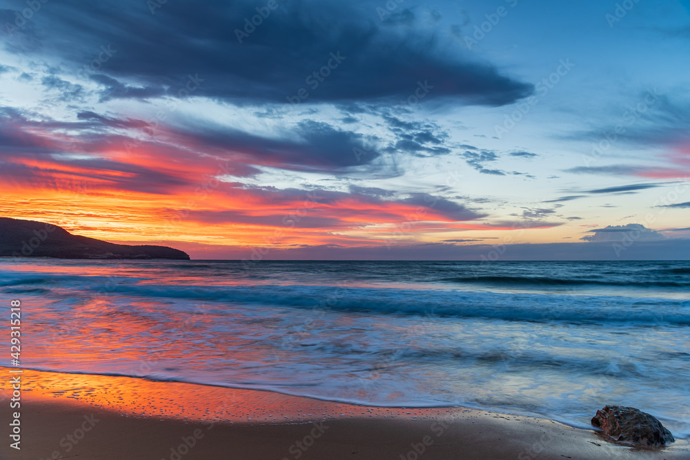 Sunrise at the seaside with pastel coloured clouds