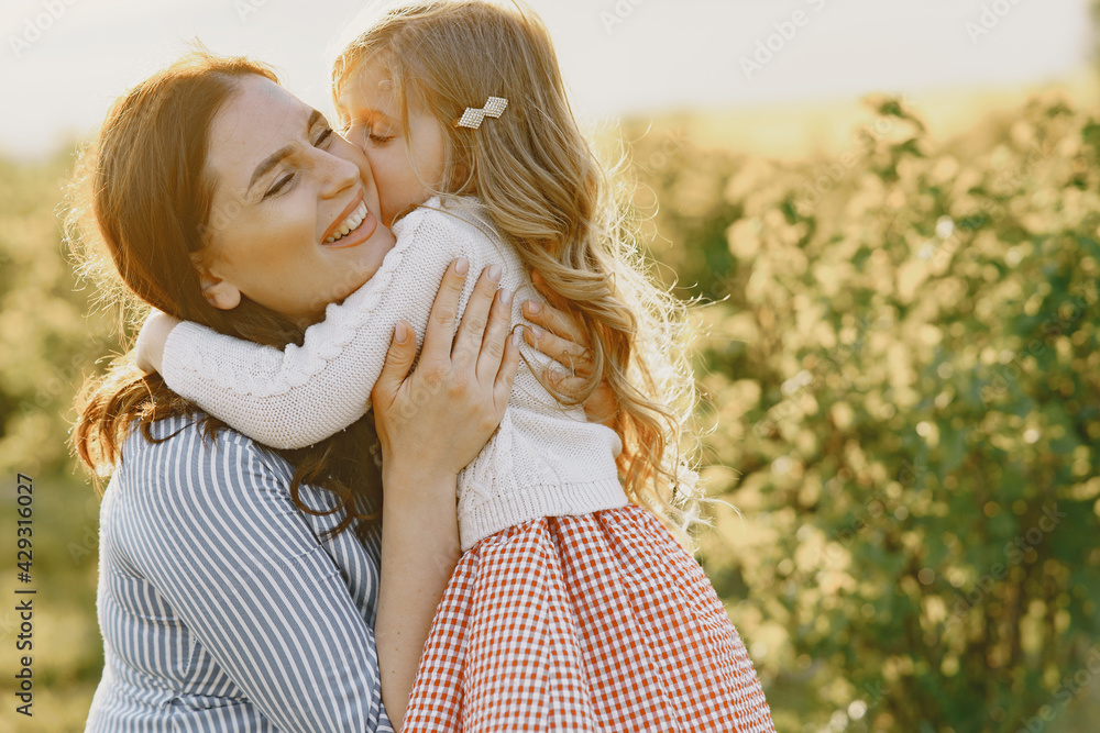 Pregnant mother with her daughter in a field Pregnant mother with her daughter in a field
