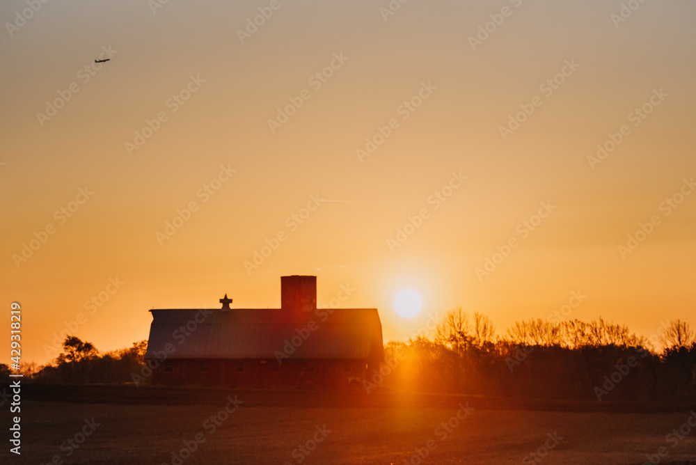 Sunrise over a barn and field