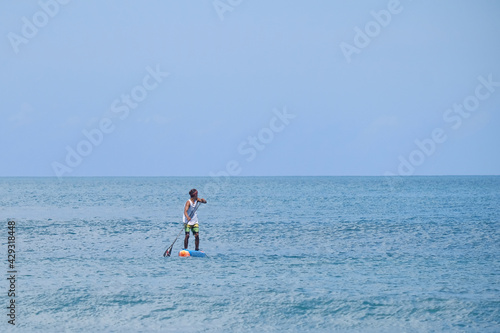Asian man playing the paddle in kuta beach