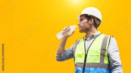 The construction worker drinks water to quench his thirst.