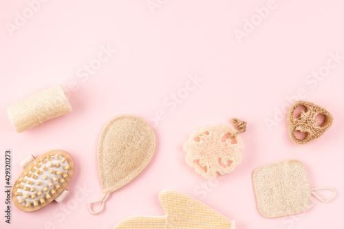 Natural hygiene products, wooden anti cellulite massager, loofah sponge, eco friendly, zero waste product. Reusable items for beauty treatment from organic biodegradable material on pink background
